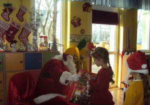 Mikołaj wręcza prezent Wiktorii